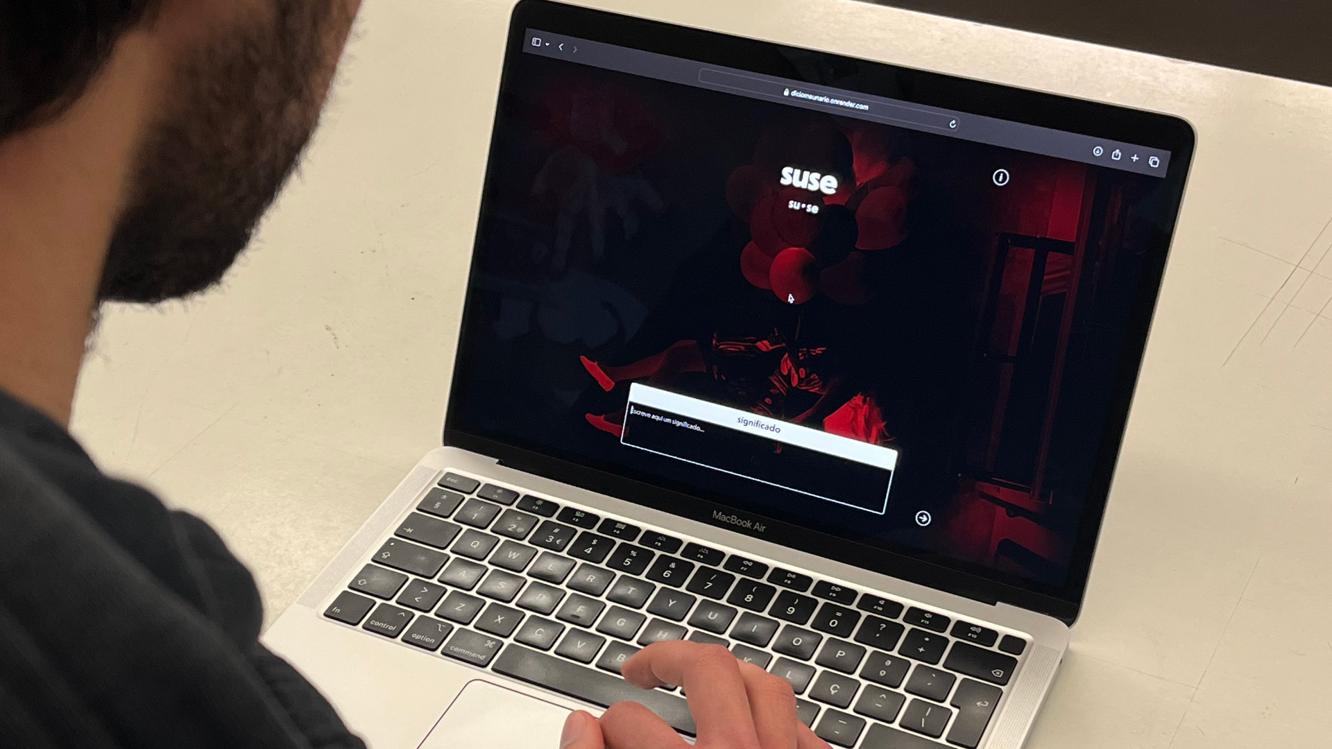 Alguém sentado em frente a um computador a escrever no teclado.